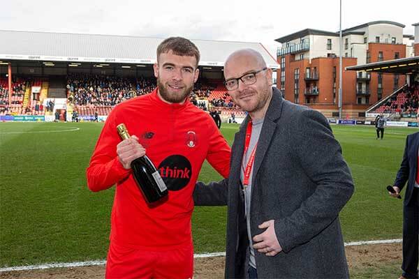 Leyton Orient player Aaron Drinan receiving goal of the month award from a male sponsor